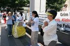 法轮功学员在西雅图Westlake Park参加世界反酷刑日,图为观众在一旁学炼功2006-6-24